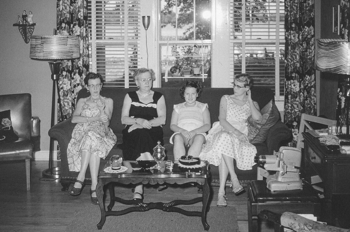 Four older women sitting on a couch talking